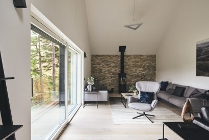 The living room with a log burner at Munro Cabin, Loch Lomond