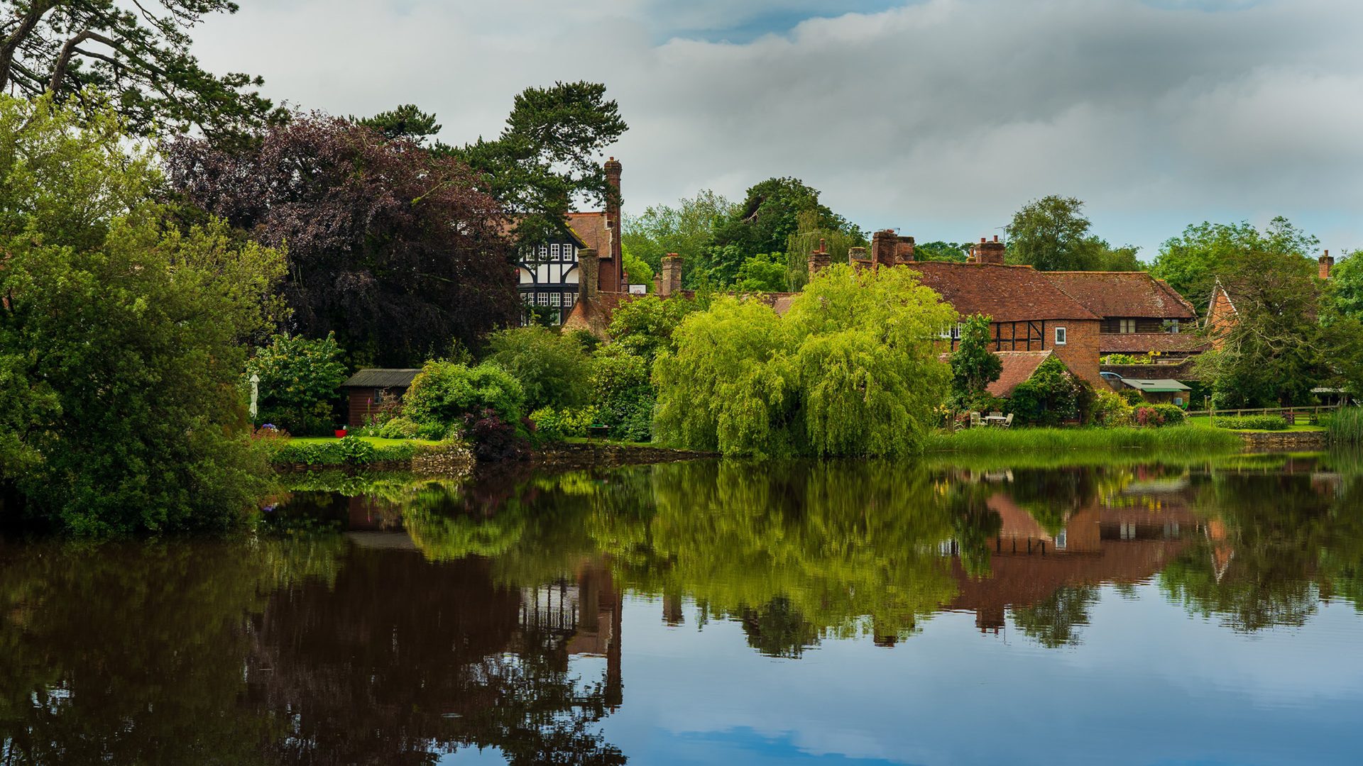 A view of Beaulieu, Brockenhurst across still water on a summer's day