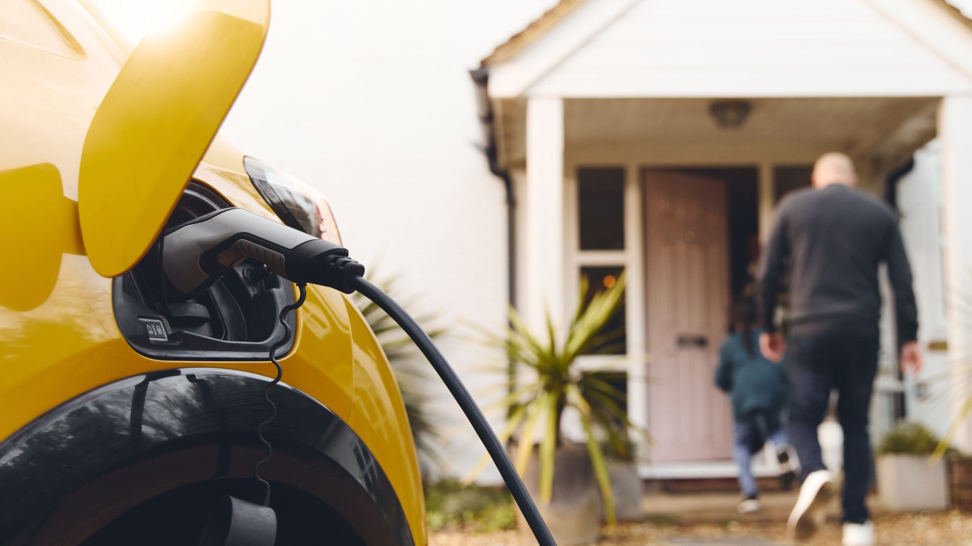 A car at an electric vehicle charging point outside a cottage