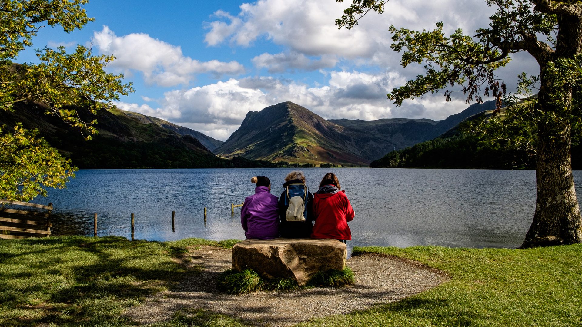 female hikers relax on a bench , Buttermere, Lake District
