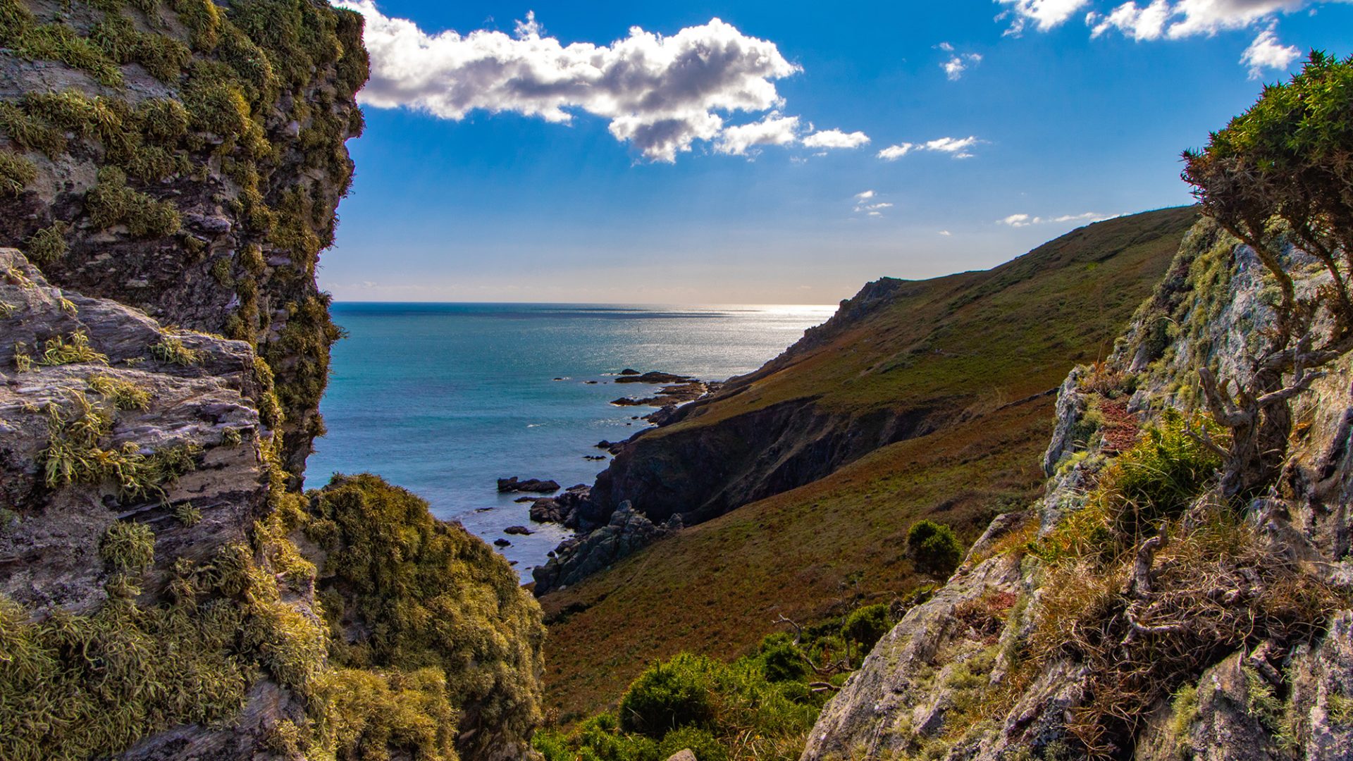 Green Hills next to sea with blue sky and cloud
